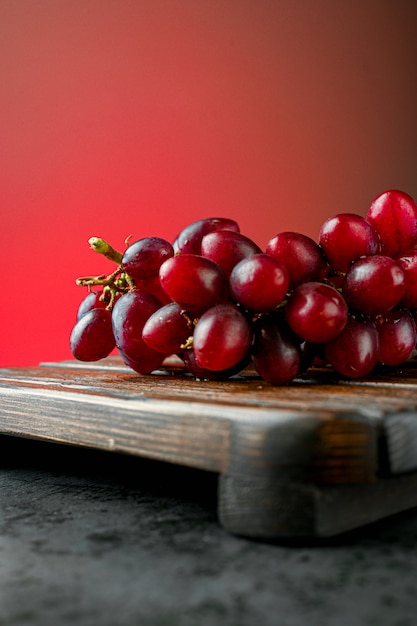 Raisins rouges sur une planche de bois