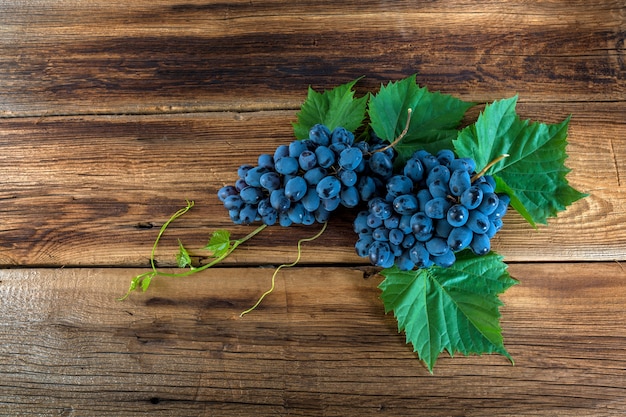 Raisins rouges avec une vigne sur un fond en bois