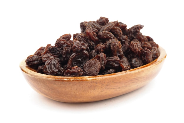 Raisins secs biologiques dans des bols en bois sur fond blanc