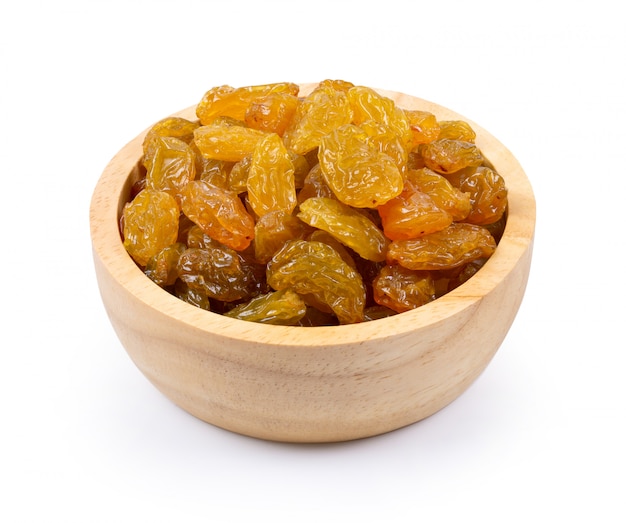 Raisins secs d'or jaune dans un bol en bois isolé