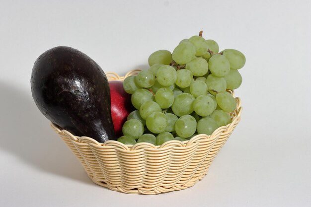 Raisins verts sur panier en osier dans un fond blanc