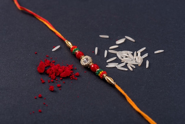 Rakhi avec grains de riz et kumkum sur fond noir