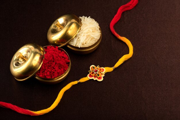 Raksha Bandhan avec un élégant Rakhi, des grains de riz et du Kumkum. Un bracelet traditionnel indien qui symbolise l'amour entre frères et soeurs.