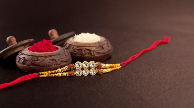 Raksha Bandhan avec un élégant Rakhi, des grains de riz et du kumkum