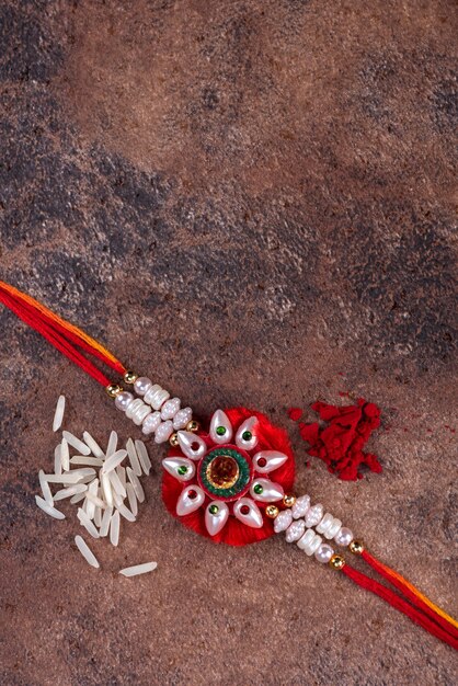 Raksha Bandhan : Rakhi avec grains de riz et kumkum sur fond de pierre