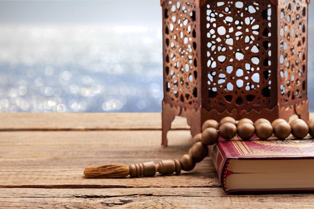Ramadan kareem signifiant ramadan béni avec le Saint Coran et la lanterne allumée