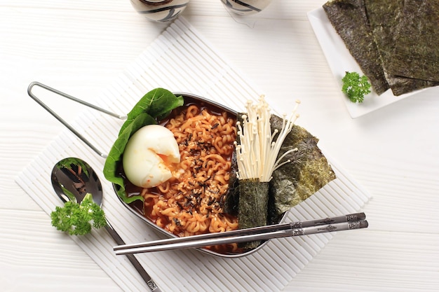Ramen instantané coréen épicé ou Ramyun avec œuf à la coque, champignons et Nori Laver. Garni de graines de sésame