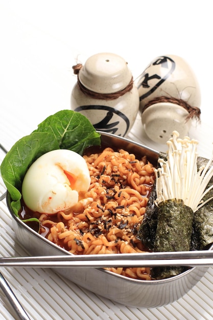 Ramen instantané coréen épicé ou Ramyun avec œuf à la coque, champignons et Nori Laver. Garni de graines de sésame