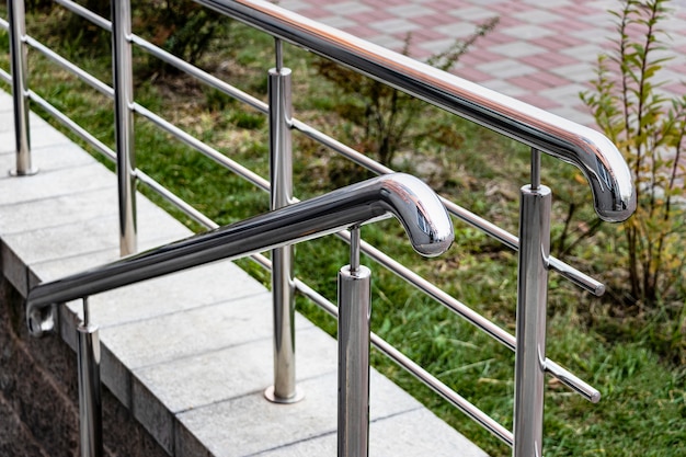 Une rampe et des garde-corps métalliques à l'entrée du bâtiment résidentiel pour le confort des personnes handicapées et des personnes âgées.