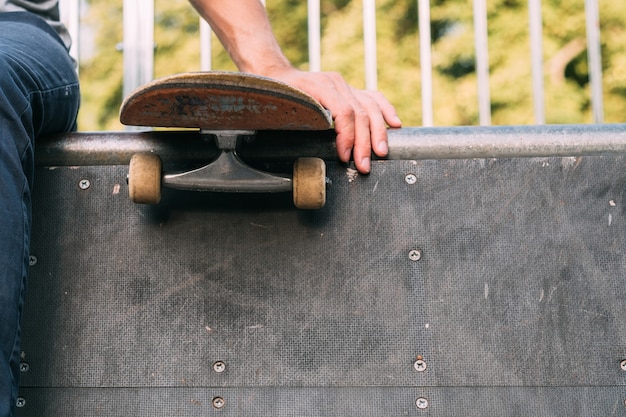 Rampe de skate park. Sports extrêmes. La culture des jeunes. Main de l'homme sur la planche à roulettes.