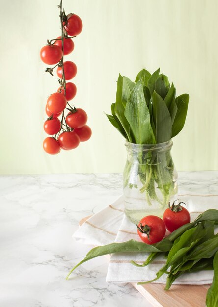 Photo ramsons et tomates cerise sur une surface de travail en marbre dans une cuisine concept d'alimentation saine