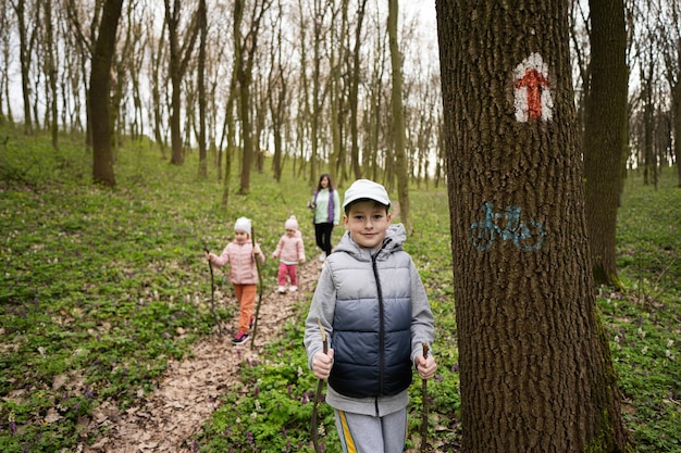 Randonnée familiale ensemble Garçon près du marqueur de sentier sur l'arbre à la forêt de printemps