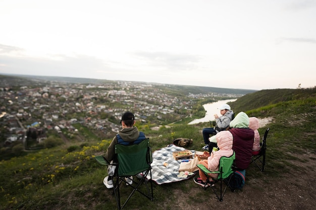 Randonnée en famille en vacances ayant un pique-nique en soirée au sommet de la montagne en regardant le magnifique paysage du canyon