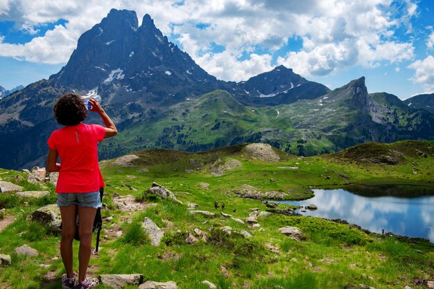 Randonnée femme buvant de l'eau et à la recherche du Pic du Midi Ossau dans les Pyrénées françaises