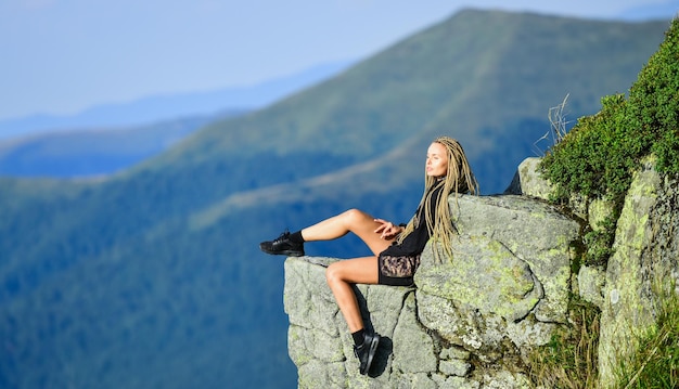 Randonnée paisible moment Profitez de la vue Touriste randonneur fille détente bord falaise Dangereux détente Concept extrême Au bord du monde Femme assise sur le bord de la falaise en arrière-plan de paysage de haute montagne