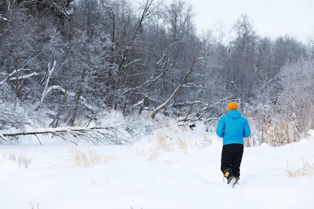 Randonnée paysage d'hiver Un homme avec un sac à dos voyage en hiver Un homme dans un champ enneigé