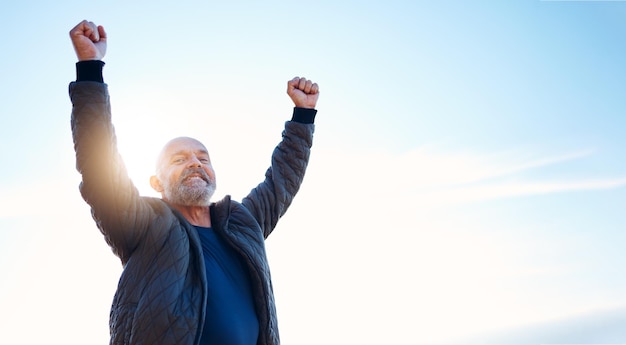 Randonnée réussie et portrait de l'homme dans la nature pour la forme physique et la liberté de voyage en Norvège Motivation excitée et personne mûre avec réalisation de célébration et victoire d'escalade sur un ciel bleu avec maquette