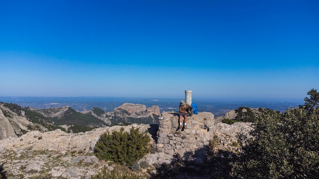 un randonneur au sommet d'une montagne avec son alpiniste de compagnie contemplant le paysage