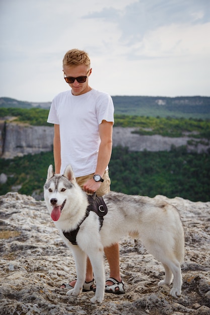 Randonneur avec chien husky sibérien regardant la belle vue dans les montagnes