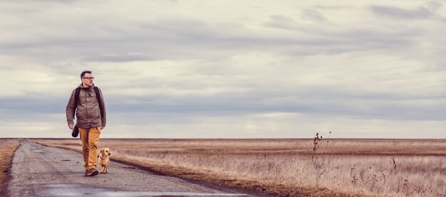 Randonneur et chien marchant sur la route