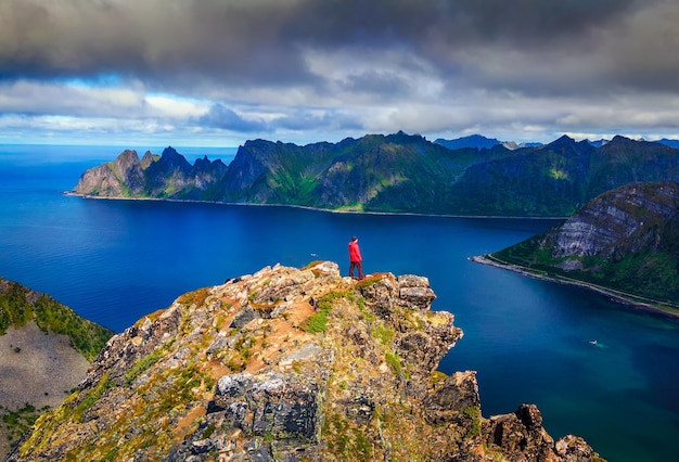 Randonneur debout au sommet de la montagne Husfjellet sur l'île de Senja en Norvège