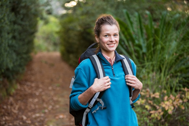 Randonneur femme debout dans la forêt avec sac à dos