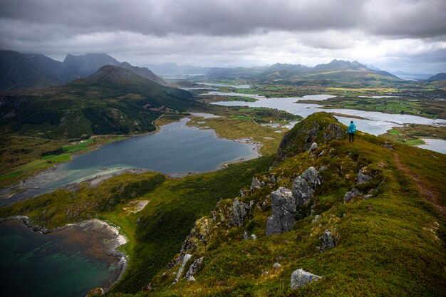 randonneur fille se dresse au sommet d'Offersoykammen profitant du panorama des îles lofoten, Norvège