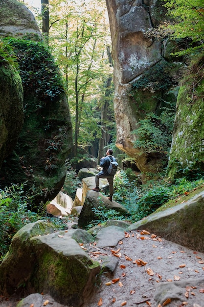 Randonneur homme avec sac à dos dans le canyon avec forêt