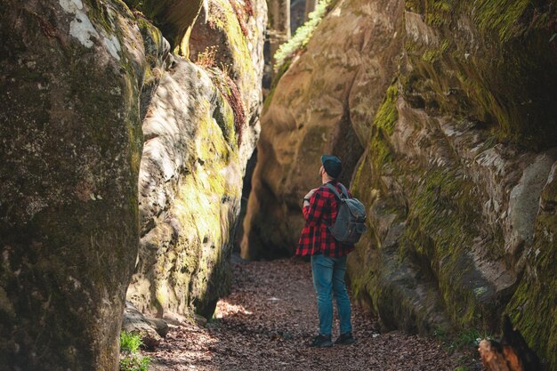 Randonneur homme avec sac à dos marchant par sentier dans le canyon