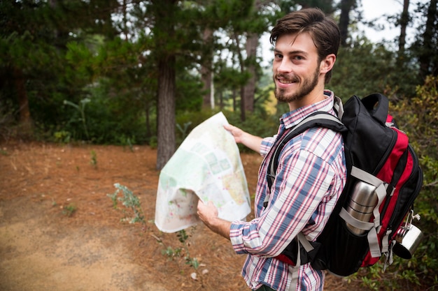 Randonneur mâle tenant une carte en forêt