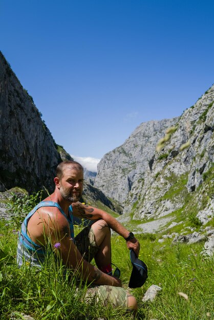 Photo un randonneur masculin dans les montagnes assis à regarder la caméra