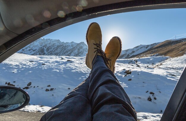 Photo randonneur pieds en bottes sur un sommet de montagne