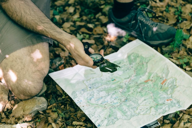 Photo un randonneur repère un chemin dans la forêt avec une boussole et une carte