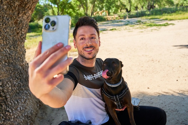 Un randonneur avec un sac à dos et un chien fait un selfie sur le téléphone