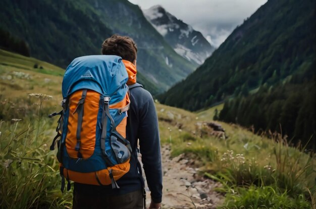 Un randonneur avec un sac à dos dans le dos marche sur une route de montagne par temps pluvieux à travers les bois