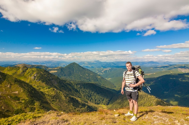 Randonneur avec un sac à dos debout dans les montagnes