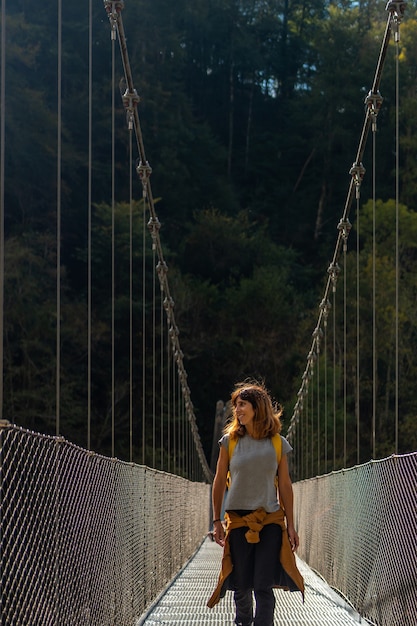 Un randonneur avec un sac à dos jaune traversant le pont suspendu Holtzarte, Larrau. Dans la forêt ou la jungle d'Irati, Pyrénées-Atlantiques de France