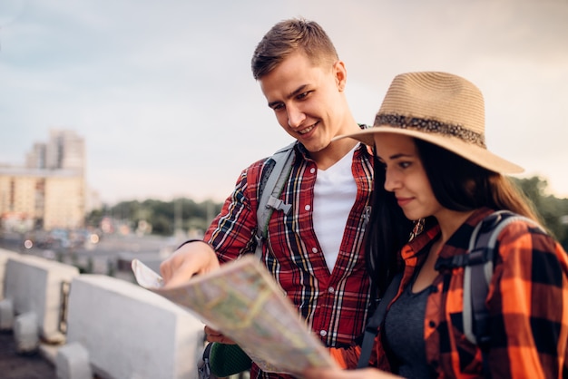 Randonneurs avec des sacs à dos regarde sur la carte, excursion en ville touristique. Randonnée d'été. Randonnée aventure de jeune homme et femme