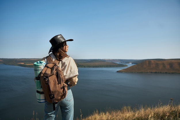 Randonneuse active avec sac à dos debout au sommet de la colline