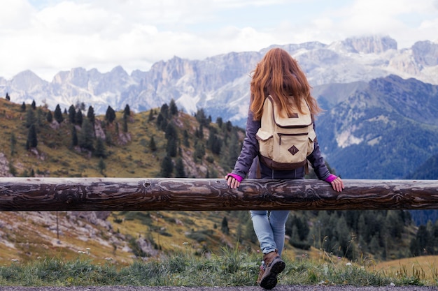 Randonneuse fille assise et regardant les montagnes enneigées. Dolomites, Italie.