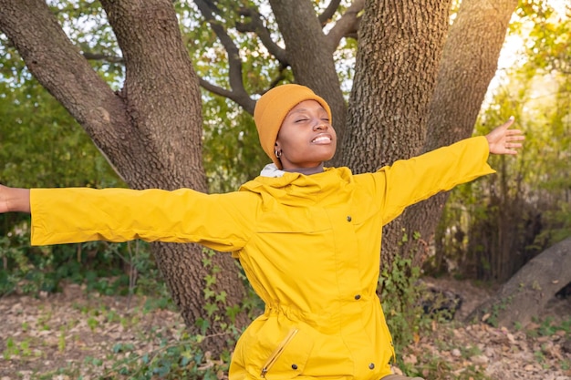 Une randonneuse en imperméable jaune avec ses mains lors d'un voyage en montagne à l'automne