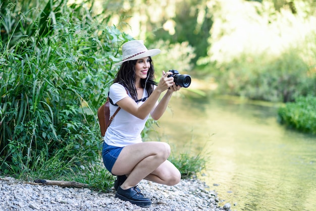 Randonneuse prenant des photos avec un appareil photo sans miroir