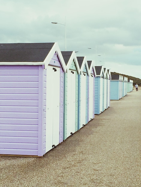 Photo une rangée de cabanes de plage contre un ciel nuageux