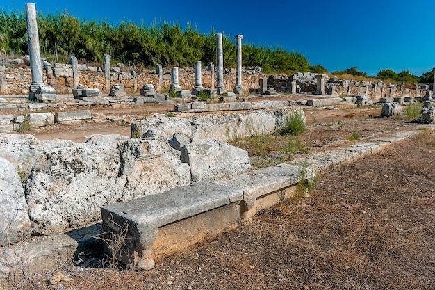 une rangée de colonnes de pierre anciennes et usées avec une lumière sur le dessus