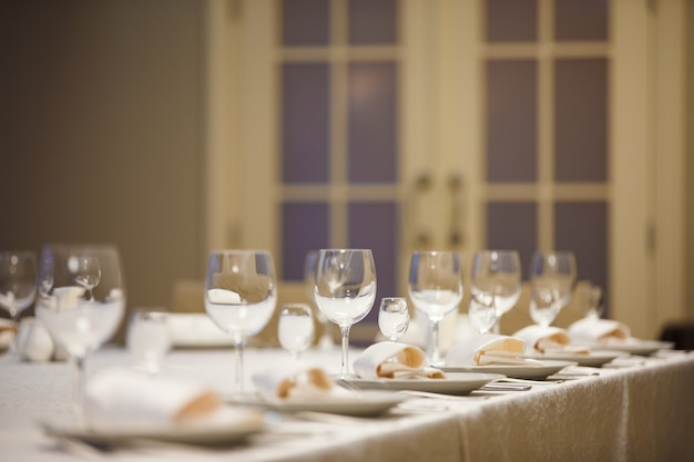 Rangée de couverts sur la table pour une réception de mariage.