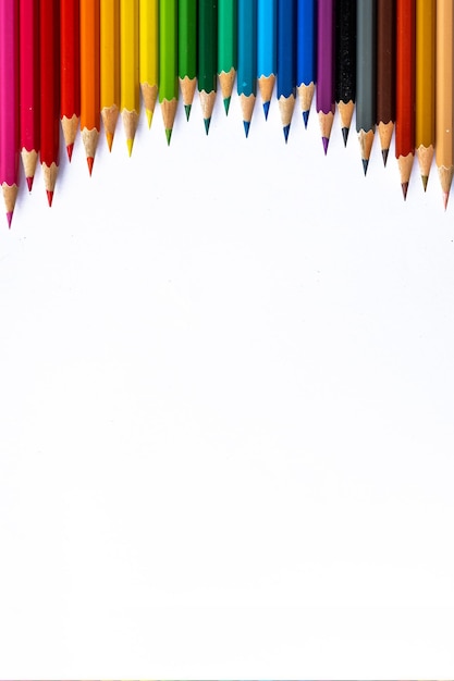 Une rangée de crayons de couleur sur fond blanc