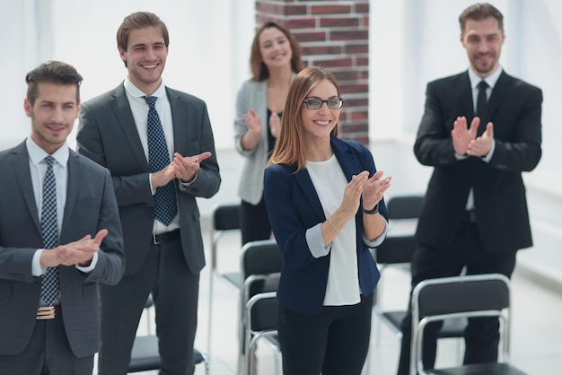 Rangée de délégués confiants applaudissant au conférencier après une présentation réussie à la conférence