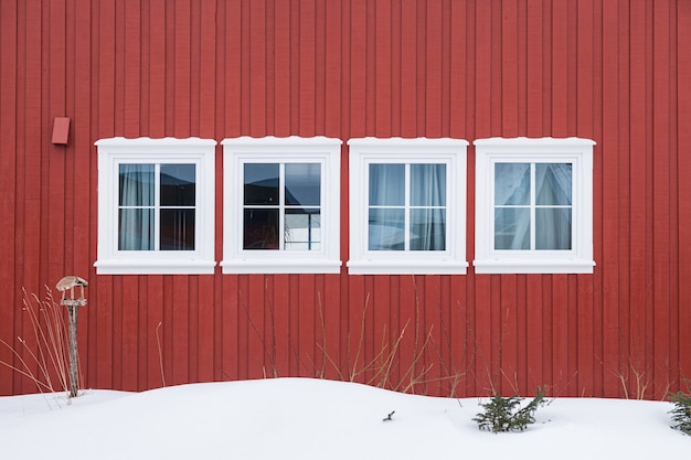 Rangée De Fenêtres Blanches Avec Mur En Bois Rouge Et Neige