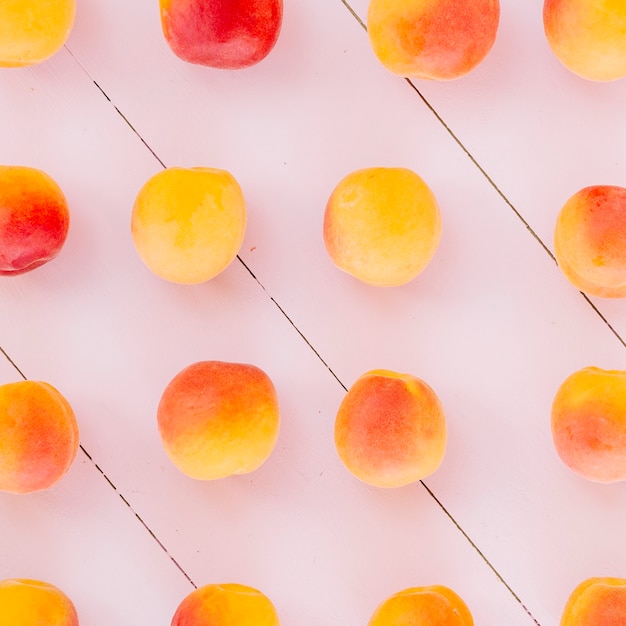 Rangée de fruits pêche sur fond en bois