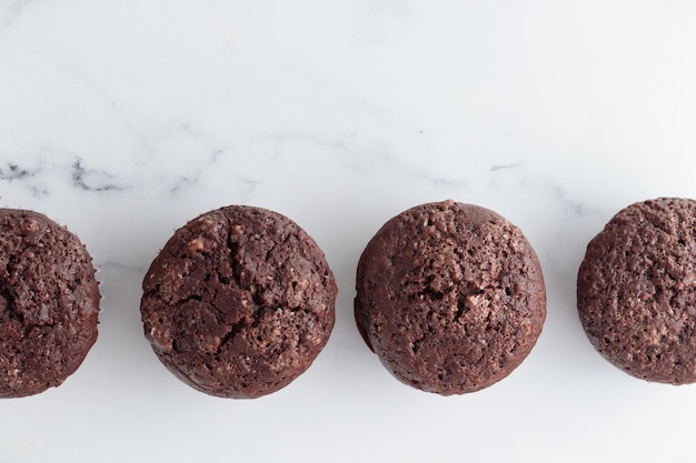 La rangée de muffins au chocolat sur une table en marbre blanc